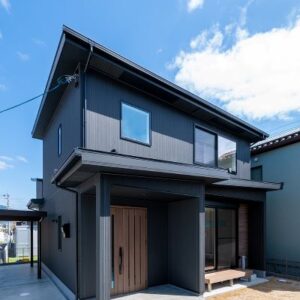 ブラックの外観に木目のぬくもりが感じられる外観。